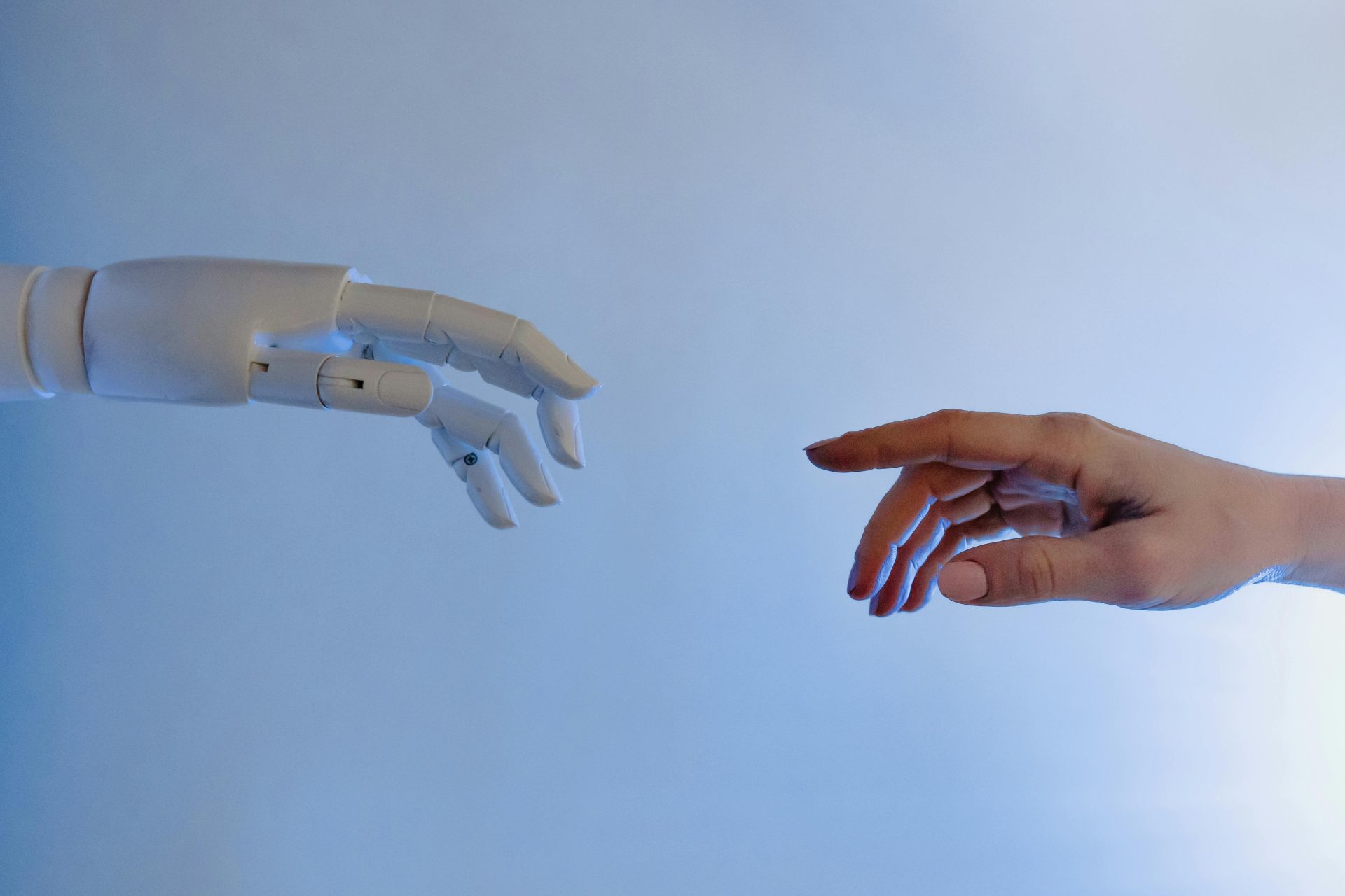 Une main humaine tendue vers une main robotique, symbolisant la technologie et la connexion.